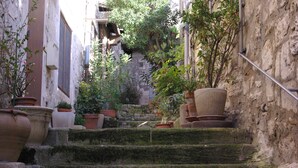 A narrow stone staircase with moss-covered steps leading up to a building.