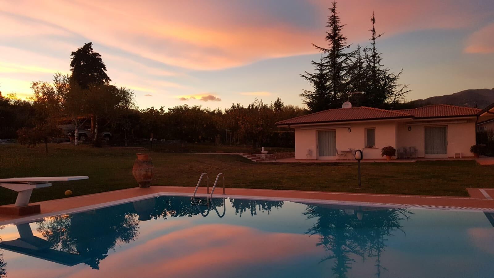 Una piscina con vistas despejadas a una casa y árboles circundantes.