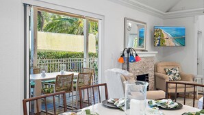 Un comedor con una mesa dispuesta para cuatro personas, una chimenea y vistas al exterior.