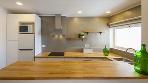 A modern kitchen with a wooden countertop, built-in microwave, and a window with a view. - B38 - Tamar 2 Bedroom Apartment in Lagos (Lagos)