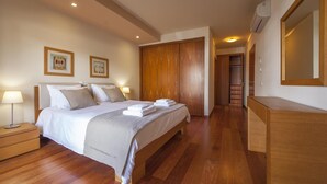 Una habitación de hotel con cama, mesitas de noche, armario y espejo.