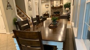 Un coin repas avec une table et des chaises en bois, un banc et une plante en pot.