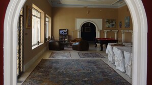 A spacious living room with a billiards table, a television, and a fireplace.