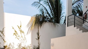 A modern outdoor pool area with lounge chairs and a staircase. - Luxury Salwater Poolside Suite | Rooftop Terrace (Sayulita)