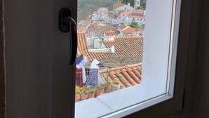 A window with a view of a town, including rooftops and buildings. - House by the Castle (360 panoramic View) (Castelo de Vide)