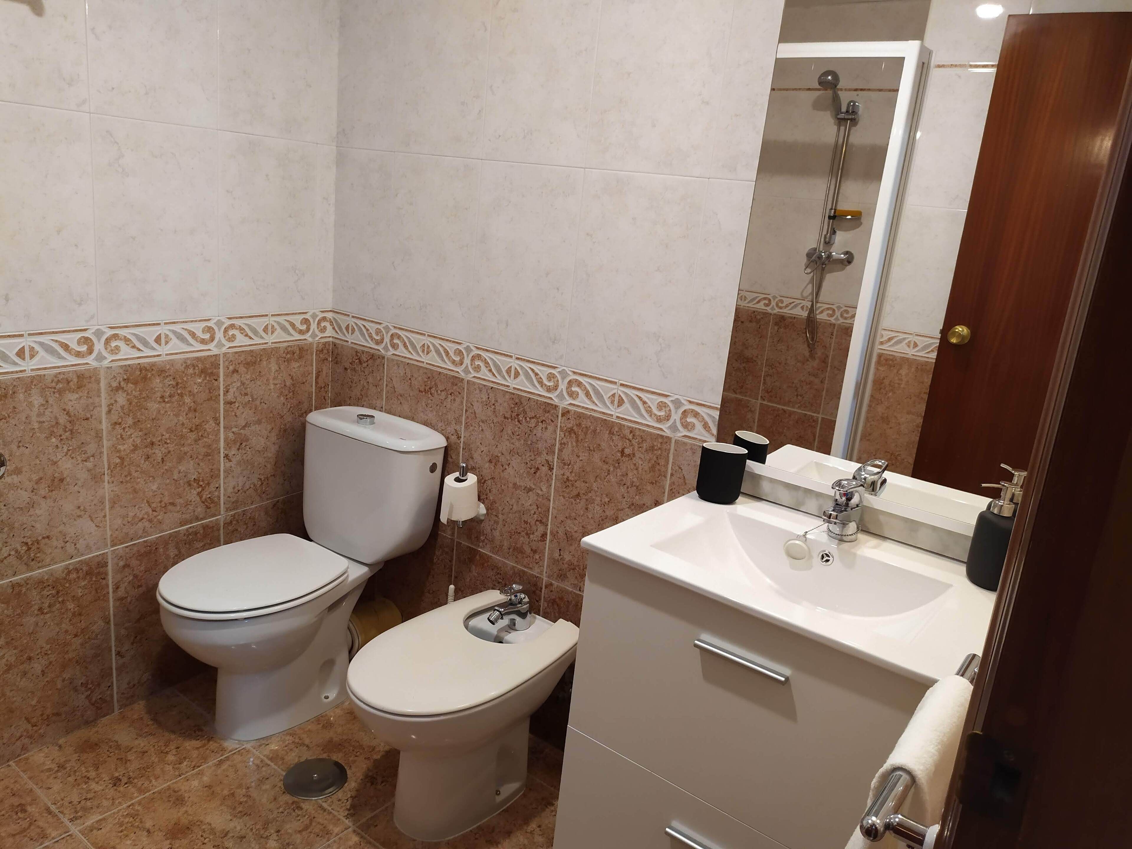 Een haardroger, handdoeken, zeep, toiletpapier