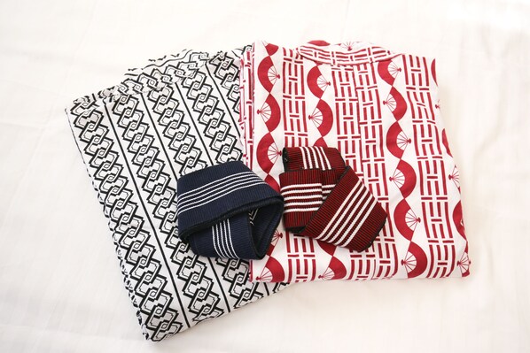 Cama bem arrumada com roupa de cama estampada e almofada listrada.