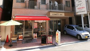 A hotel with multiple balconies, a red awning, and a sign for a restaurant.