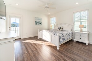 A bedroom with a bed, nightstand, dresser, and a ceiling fan.
