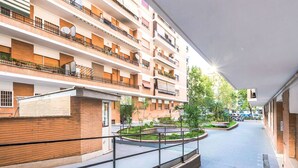 A multi-story residential building with balconies, a central courtyard, and a staircase leading to the upper floors. - Cosy apartment for 6 guests with WIFI, A/C, TV and balcony (Rome)