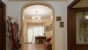 A hallway leading to a living room with a chandelier, a dining table, and a sofa. - Cosy apartment for 6 guests with WIFI, A/C, TV and balcony (Rome)