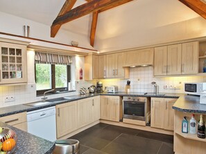 A modern kitchen with wooden cabinets, a built-in oven, a microwave, and a sink. - 3 bedroom accommodation in St Issey, Wadebridge (St Issey, Wadebridge)