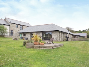 A stone house with a patio, outdoor seating, and a grassy yard. - 3 bedroom accommodation in St Issey, Wadebridge (St Issey, Wadebridge)