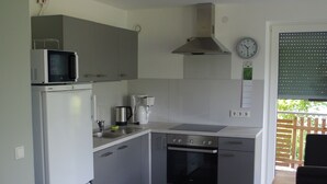 A compact kitchen with a microwave, stove, and sink. - New vacation apartment in Neckargemünd near Heidelberg (Neckargemünd)