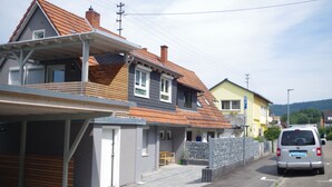 A residential street with houses, a covered parking area, and a parked van. - New vacation apartment in Neckargemünd near Heidelberg (Neckargemünd)
