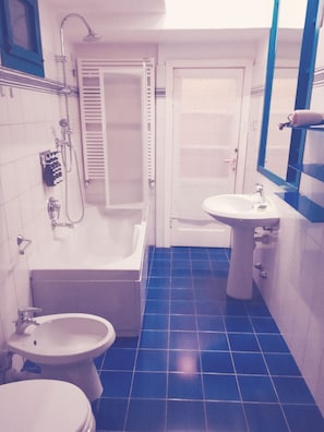 Um banheiro com banheira, vaso sanitário e pia.