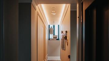 A hallway with patterned flooring, a light fixture on the ceiling, and framed pictures on the wall.
