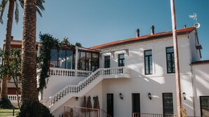 A white building with a red-tiled roof, a staircase, and a balcony. - 1930 Boutique Hotel (Arzua)