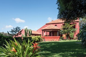 A red building with a tiled roof, surrounded by greenery and a well-maintained lawn. - Luxury Villa in an idyllic setting, in Santa Brígida, Gran Canaria. (Santa Brigida)
