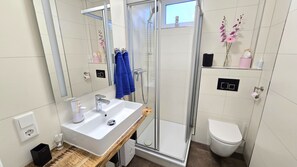 Shower, hair dryer, slippers, towels