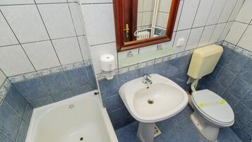 A bathroom with a bathtub, a sink, and a toilet.