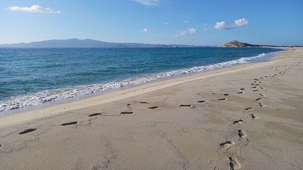 A beach with footprints leading to the water, a clear sky, and distant mountains. - Naxos is the Way Summer Dream 3 apartment (Kastraki)