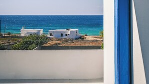 A view from a window overlooking a coastal area with a clear sky, a building, and the sea. - Naxos is the Way Summer Dream 3 apartment (Kastraki)