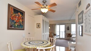 A dining area with a round table, chairs, a ceiling fan, and a painting on the wall. - Flood Damaged - Renovated 2026 ~ Excuse Glitches - Still Quaint VINTAGE Studio (Rehoboth Beach)