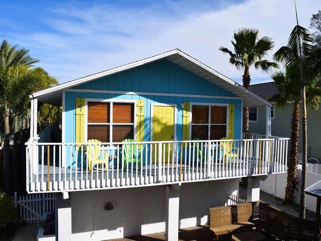 Une maison à deux étages dotée d’un balcon, d’un porche couvert et d’une petite terrasse.