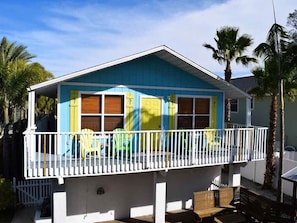 A two-story house with a balcony, a covered porch, and a small deck.