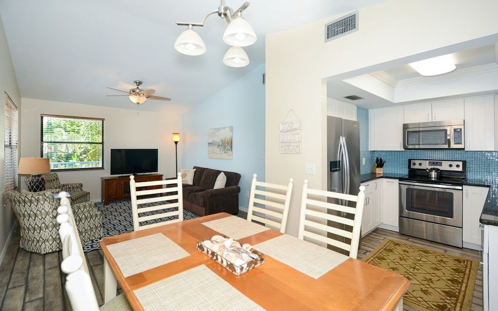 A compact living space with a dining area, kitchenette, and a ceiling fan.