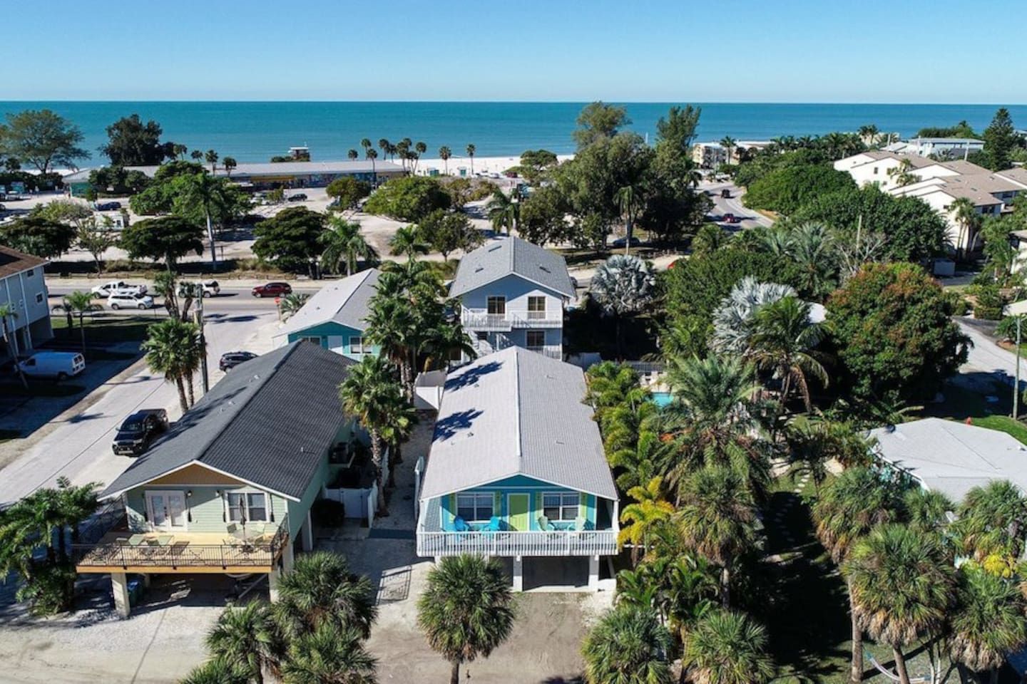 A coastal residential area with houses, a beach, and a clear view of the ocean.