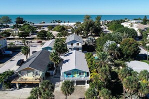 A coastal residential area with houses, a beach, and a clear view of the ocean.