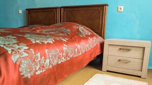 Un dormitorio con cama, mesita de noche y alfombra.
