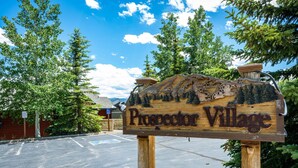 A wooden sign with the text "Prospector Village" and a mountain landscape carving. - Exceptional Views, Large Townhome, Hot Tub, Pool, Private Garage 97A (Silverthorne)