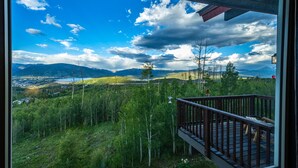A balcony with a view of a mountainous landscape, a lake, and a town in the distance. - Exceptional Views, Large Townhome, Hot Tub, Pool, Private Garage 97A (Silverthorne)