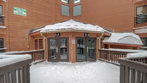 Edificio de madera con dos entradas identificadas con AA y BB, rodeado de nieve.