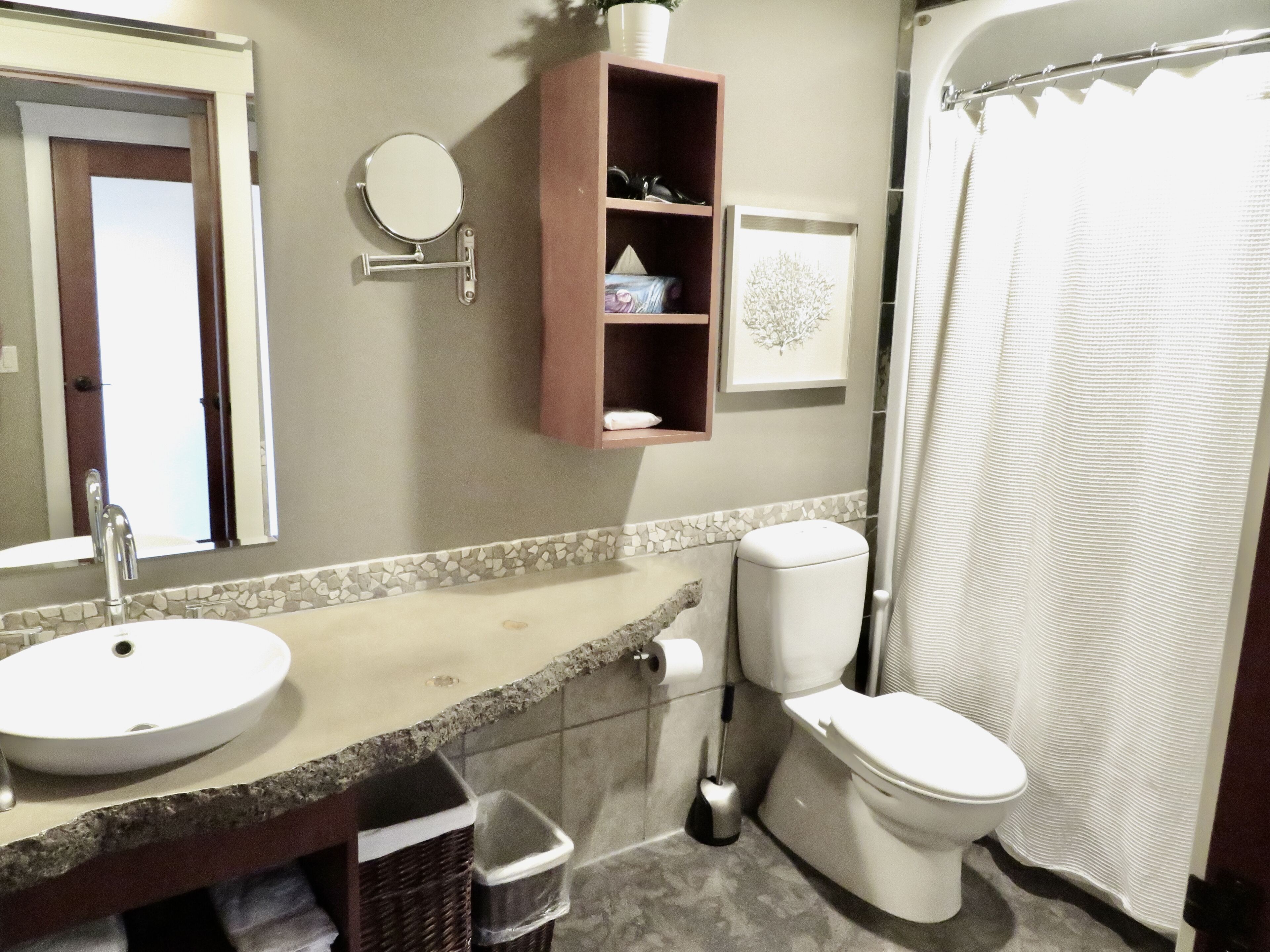 Un baño con lavamanos, inodoro y cortina de ducha.