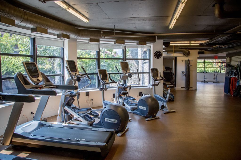 Un gimnasio con cintas de correr, elípticas y bicicletas estáticas.