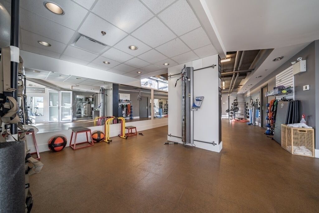 A gym with exercise equipment, a mirror, and a large window.
