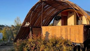A dome-shaped wooden structure with a visible interior, surrounded by vegetation. - Tu Glamping (Chocontá)