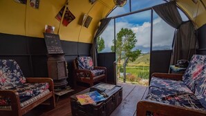 A cozy room with wooden furniture, a vintage suitcase, and a chalkboard menu. - Tu Glamping (Chocontá)
