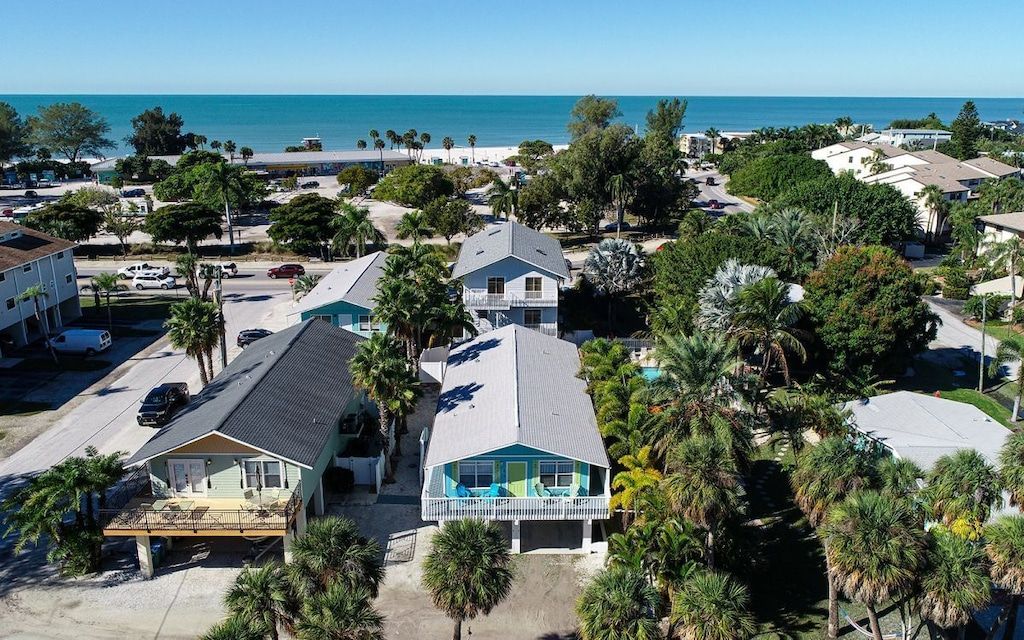 Un quartier résidentiel avec des maisons, une plage et un ciel dégagé.