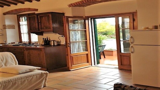 Una cocina con armarios de madera, una estufa y un refrigerador.