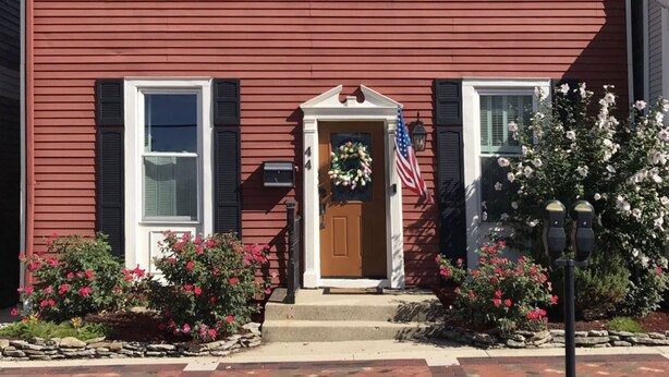 A two-story house with a red exterior, black shutters, and a front door with a wreath and American flag. - Downtown Lebanon, Near Kings Island, Lovely Historic Home, 1st Flr, Washer/Dryer (Lebanon)