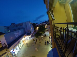 A nighttime view of a pedestrian area with shops and people walking. - Apartments LAVO (Ohrid)