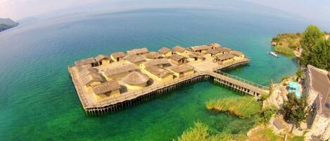 An overwater resort with multiple bungalow-style accommodations connected by walkways.