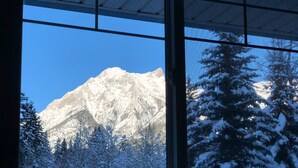 A window view of a snow-covered mountain with a clear sky.