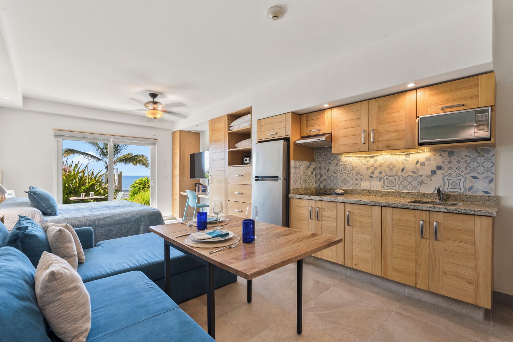 A modern kitchen with wooden cabinets, a built-in microwave, and a tiled backsplash.