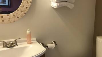 Un baño con lavamanos, inodoro y perchero para toallas.